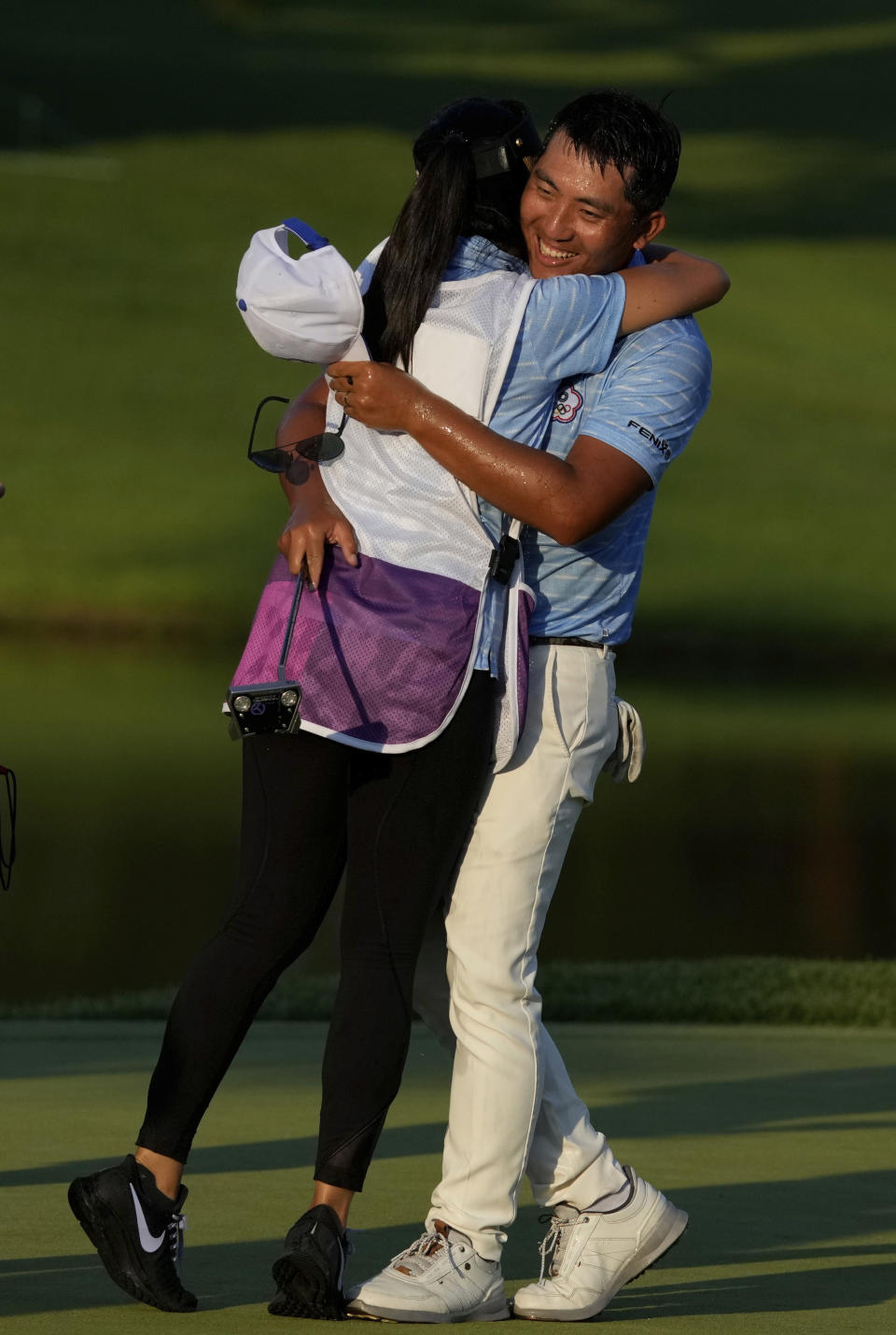 Cheng Pan of Taiwan is congratulated by his caddie after winning the bronze medal during the final round of the men's golf event at the 2020 Summer Olympics on Sunday, Aug. 1, 2021, in Kawagoe, Japan. (AP Photo/Andy Wong)
