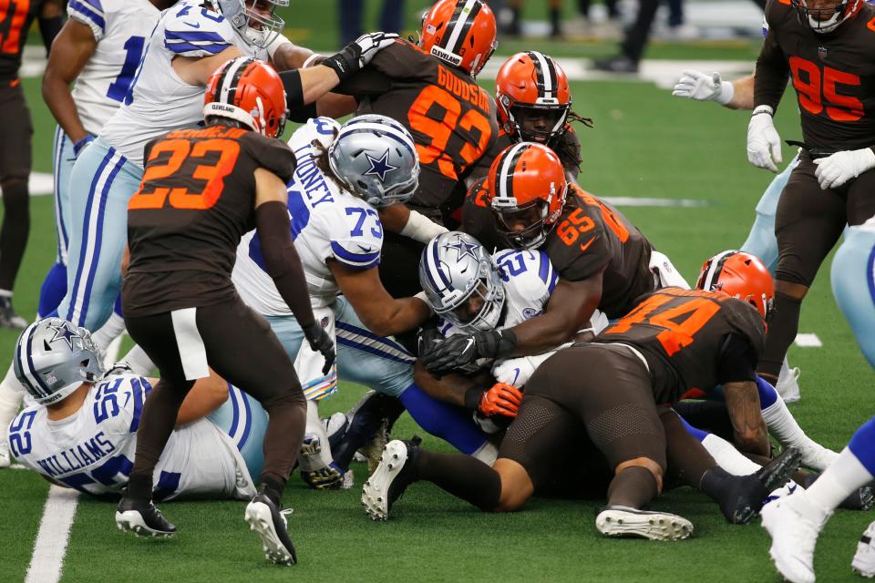 Cowboys running back Ezekiel Elliott is tackled by Cleveland Browns defensive tackle Larry Ogunjobi (65) in the first quarter, Oct. 4, 2020, in Arlington, Texas.