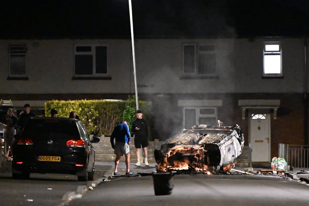 Shortly before midnight a car was set on fire and burned fiercely, while a second vehicle was overturned and set ablaze (Getty Images)