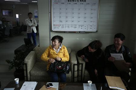 Gao Yiai (C), 35, from China's Shandong province, reacts as she talks with a driving instructor at a driving school in Siheung March 27, 2014. Chinese shoppers already have a seemingly insatiable appetite for South Korean pop music, TV dramas, cosmetics and fashion. Now they're after another must-have item: a driver's licence. In China, would-be drivers can wait. REUTERS/Kim Hong-Ji
