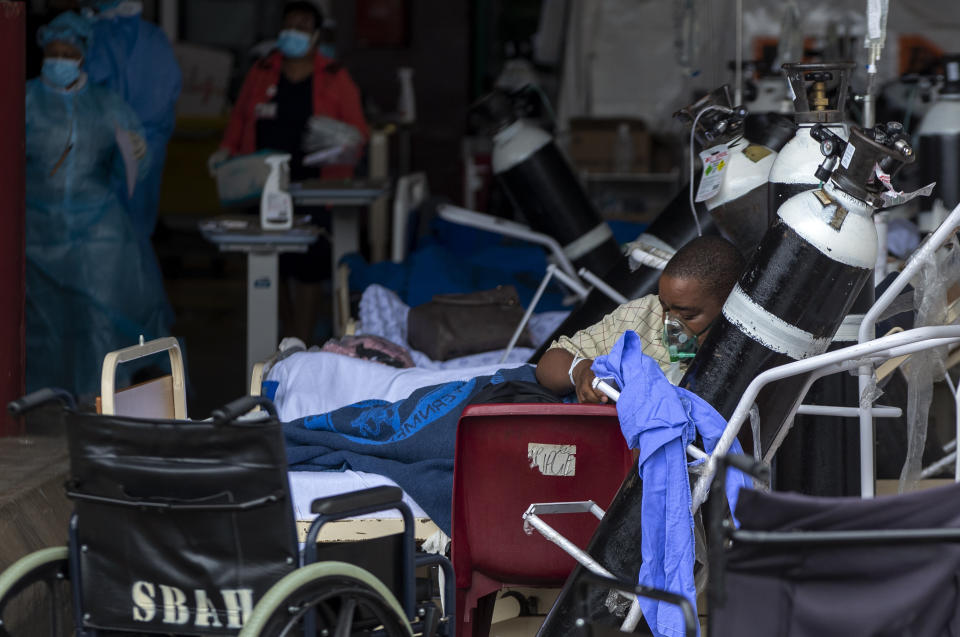 A patient wearing an oxygen mask is being treated in the makeshift emergency unit at Steve Biko Academic Hospital in Pretoria, South Africa, Monday, Jan. 11, 2021, which is battling an ever-increasing number of Covid-19 patients. (AP Photo/Themba Hadebe)