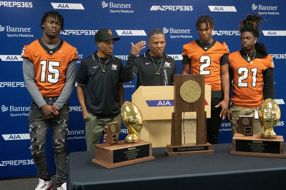 Desert Edge High football coaches Mark Carter, left, and his brother Marcus Carter speak during the Arizona Interscholastic Association high school state football championship media day on Nov. 29, 2023 in Phoenix. Standing with the coaches are players, Deshawn Warner, (15), Hezekiah Millender, (2), and Aundre Gibson, (21). Mandatory Credit: Cheryl Evans-Arizona Republic