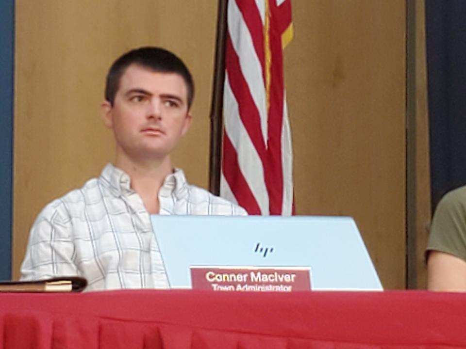 Town Administrator Conner MacIver listens as the merits of a special warrant article calling for his removal, and that of town Treasurer Peter Royce are discussed in a special town meeting Saturday.