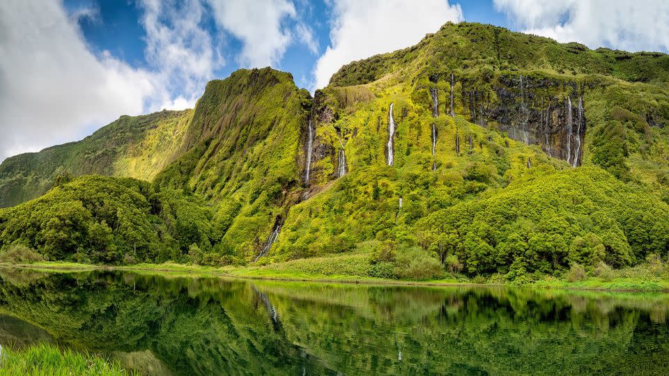 Waterfalls trickle down an imposing rock face on the island Flores in the Azores. - aroxopt/Adobe Stock