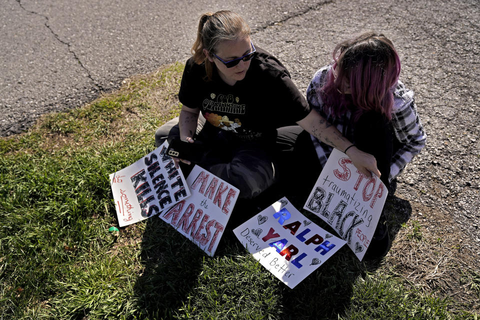 Trisha Loftis and her daughter Ashlyn, 13, sit outside the house where 16-year-old Ralph Yarl was shot several days earlier when he went to the wrong address to pick up his brothers, Monday, April 17, 2023, in Kansas City, Mo. (AP Photo/Charlie Riedel)