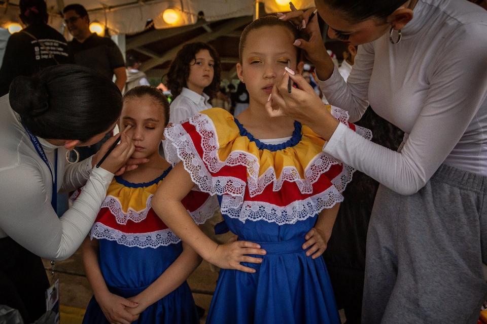 Left to right: Claudia Castillo of Coral Springs, Lucia Alemany of Weston, Sienna Reyes of Davie and Megan Lara of Coral Springs finish their makeup before a dance performance Saturday at the Fiesta de Pueblo-Three Kings Day celebration at Samuel J. Ferreri Community Park in Greenacres.