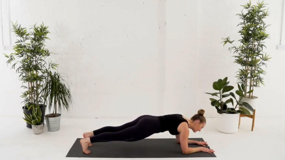 Veronique Ellis, founder of Evolve PIlates, demonstrating low plank to downward dog variation