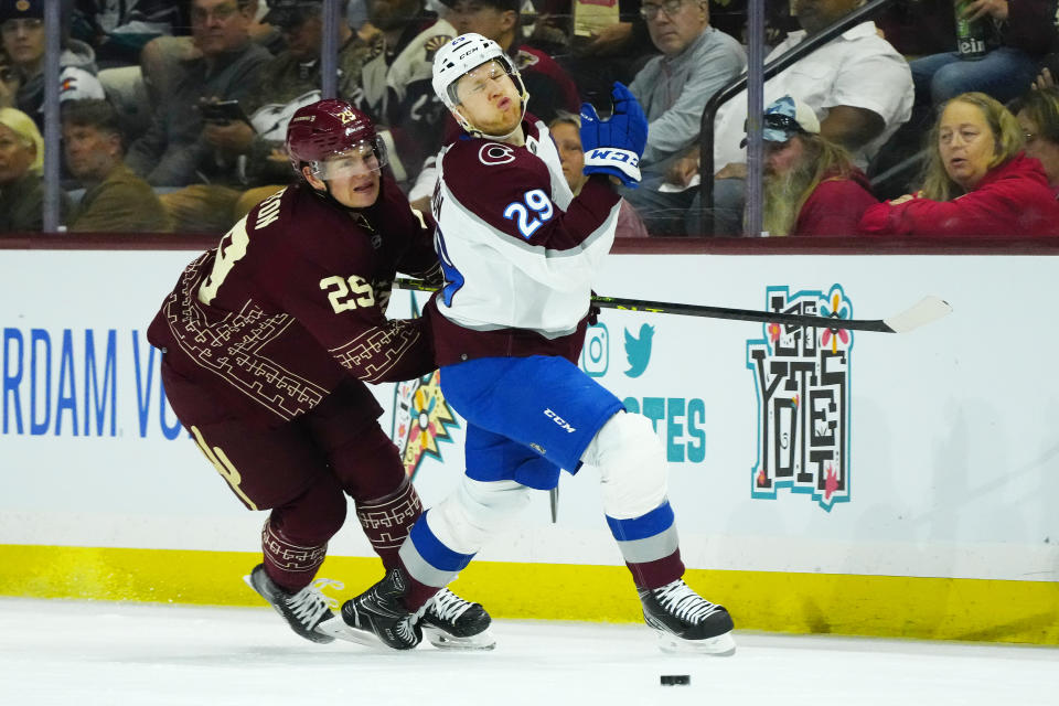 Arizona Coyotes center Barrett Hayton (29) shoves Colorado Avalanche center Nathan MacKinnon (29) off the puck during the second period of an NHL hockey game, Sunday, March 26, 2023, in Tempe, Ariz. (AP Photo/Ross D. Franklin)
