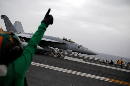 U.S. Navy flight deck personnel use hand signals as an F/A-18 fighter jet prepares to take off from the USS Harry S. Truman aircraft carrier in the eastern Mediterranean Sea, May 4, 2018. REUTERS/Alkis Konstantinidis