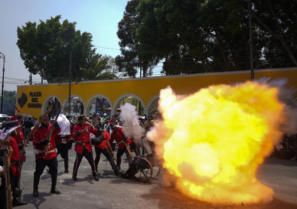 A man fires a cannon gun during a recreation of the Battle of Puebla between the Zacapoaxtlas Indians and French army at the Cinco de Mayo celebrations, in the Peñon de los Baños neighborhood of Mexico City, Thursday, May 5, 2022. Cinco de Mayo commemorates the victory of an ill-equipped Mexican army over French troops in Puebla on May 5, 1862. (AP Photo/Eduardo Verdugo)