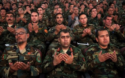 Afghan army soldiers pray during a ceremony to introduce the new chief of the intelligence service, in Kabul, Afghanistan, Monday, Sept. 9, 2019. - Credit: AP