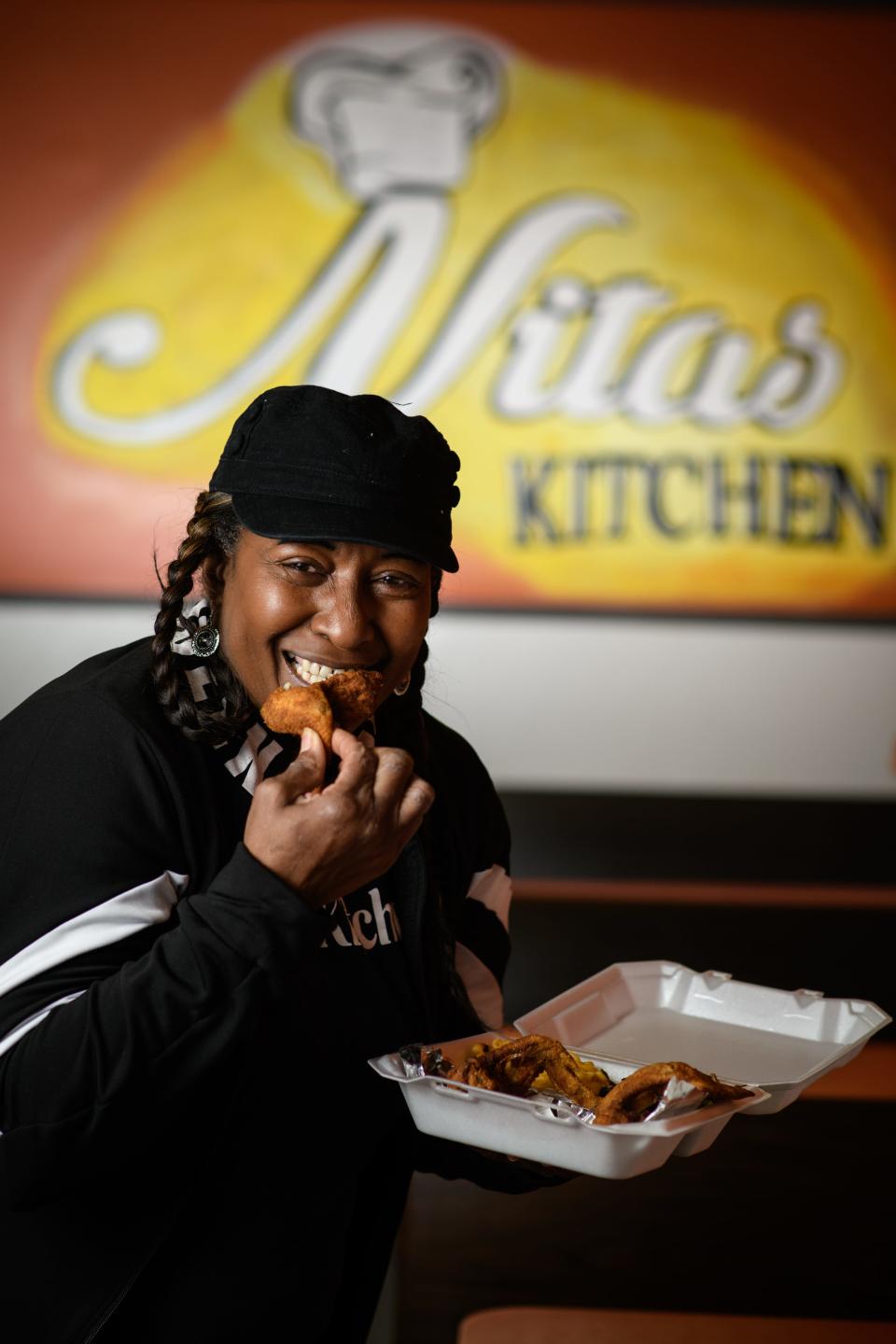Anita Tucker, owner of Nita's Kitchen, takes a bite out of a wing from her restaurant, which is located on Cliffdale Road.