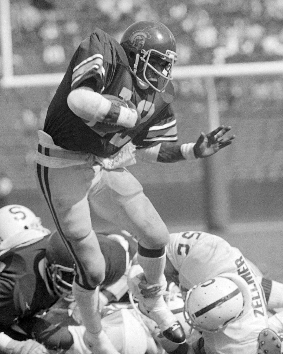 FILE - Southern California tailback Charles White (12) carries for a first down against Stanford during an NCAA college football game in Los Angeles, Oct. 13, 1979. White died Wednesday, Jan. 11, 2023. He was 64. USC announced the death of White, who is still the Trojans' career rushing leader with 6,245 yards. The nine-year NFL veteran died of cancer, the school said. (AP Photo, File)