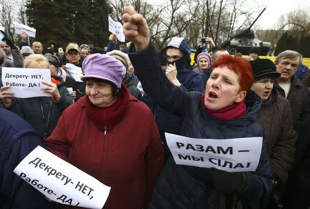 People shout slogans during a protest against increased tariffs for communal services and new taxes, including the tax for those who are not in full-time employment, in the town of Bobruisk, Belarus March 12, 2017. The placards read, "No to decree, yes to work!" (L), "Together we are a force!" REUTERS/Vasily Fedosenko