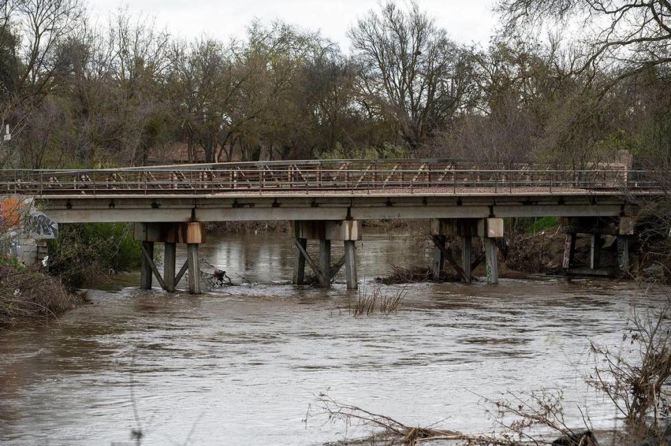 Bear Creek flows past a railroad bridge near West 25th Street in Merced, Calif., on Tuesday, March 14, 2023.