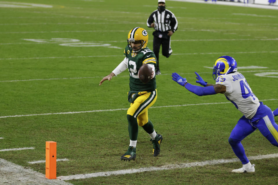 Green Bay Packers quarterback Aaron Rodgers scores on a one-yard touchdown run past Los Angeles Rams' John Johnson during the first half of an NFL divisional playoff football game, Saturday, Jan. 16, 2021, in Green Bay, Wis. (AP Photo/Matt Ludtke)