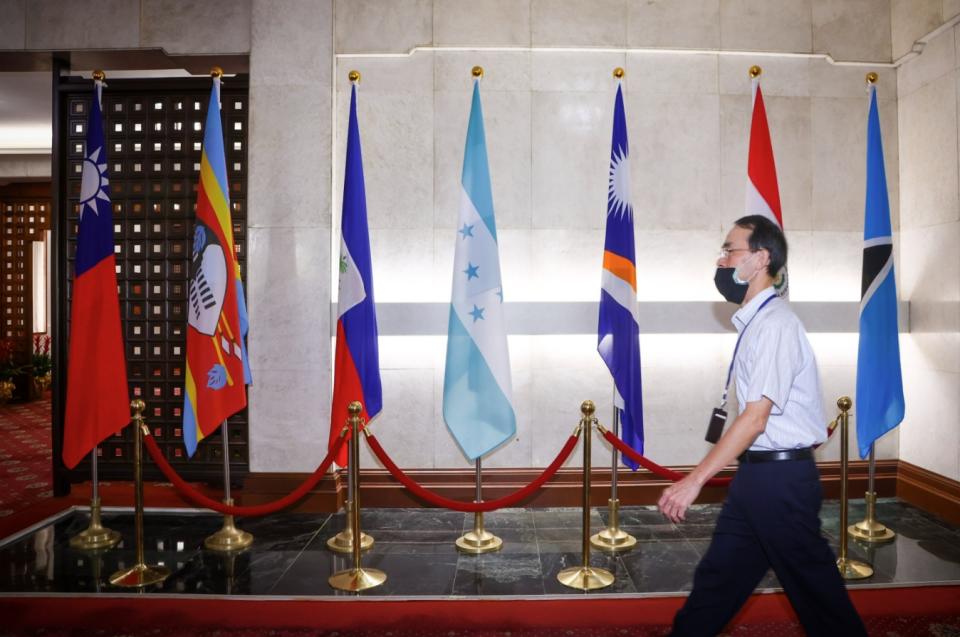 宏都拉斯外長赴中國大陸洽商建交，外交部召回駐宏國大使表達強烈不滿。圖為外交部員工經過一樓大廳宏都拉斯國旗（左4）。（中央社）
