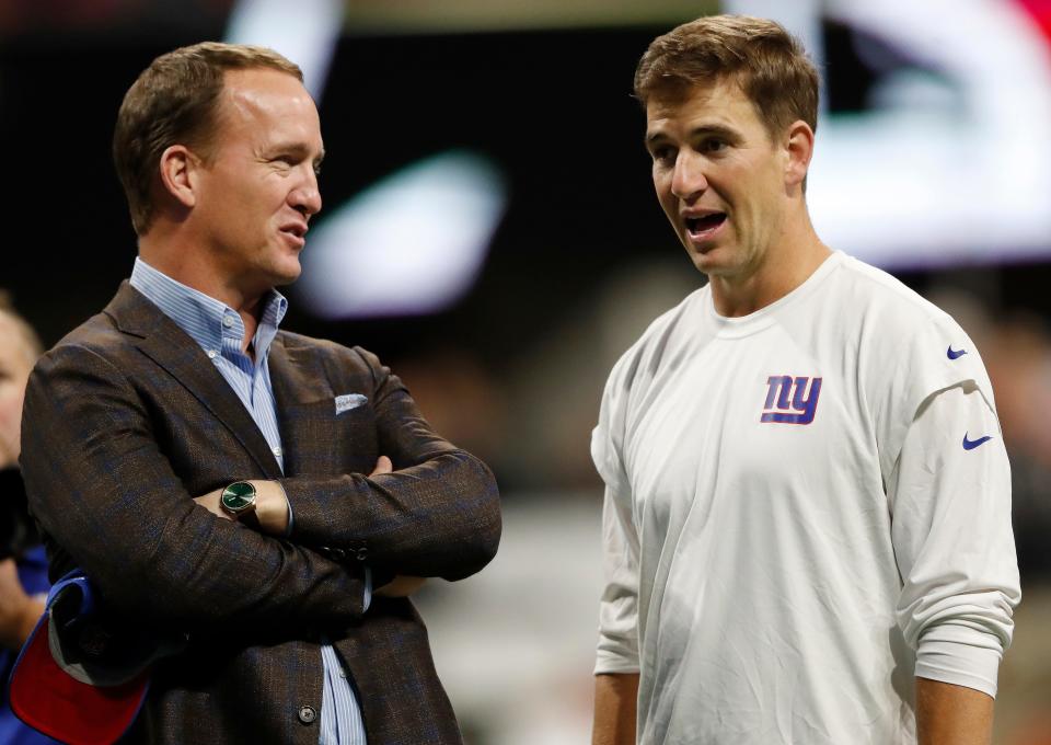 Former NFL quarterback Peyton Manning, left speaks with younger brother New York Giants quarterback Eli Manning before an NFL football game between the Atlanta Falcons and the New York Giants, Monday, Oct. 22, 2018, in Atlanta. (AP Photo/John Bazemore)