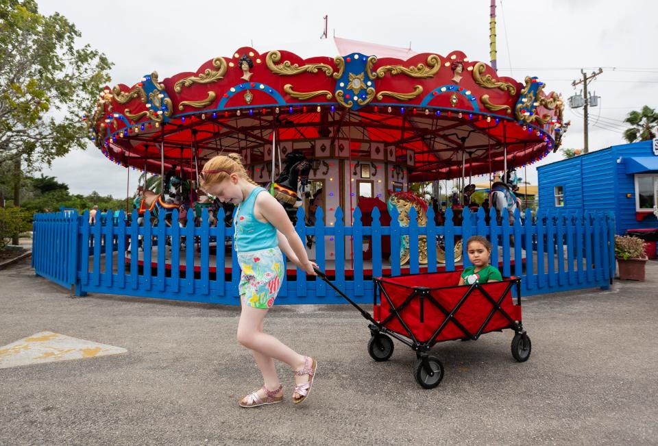 Judy Pollock, 8, from Scotland pulls her cousin Teaghan Privatera, 8, in a wagon after riding a restored 1927 carousel at The Shell Factory and Nature Park on Saturday, Dec. 21, 2019, in North Fort Myers.