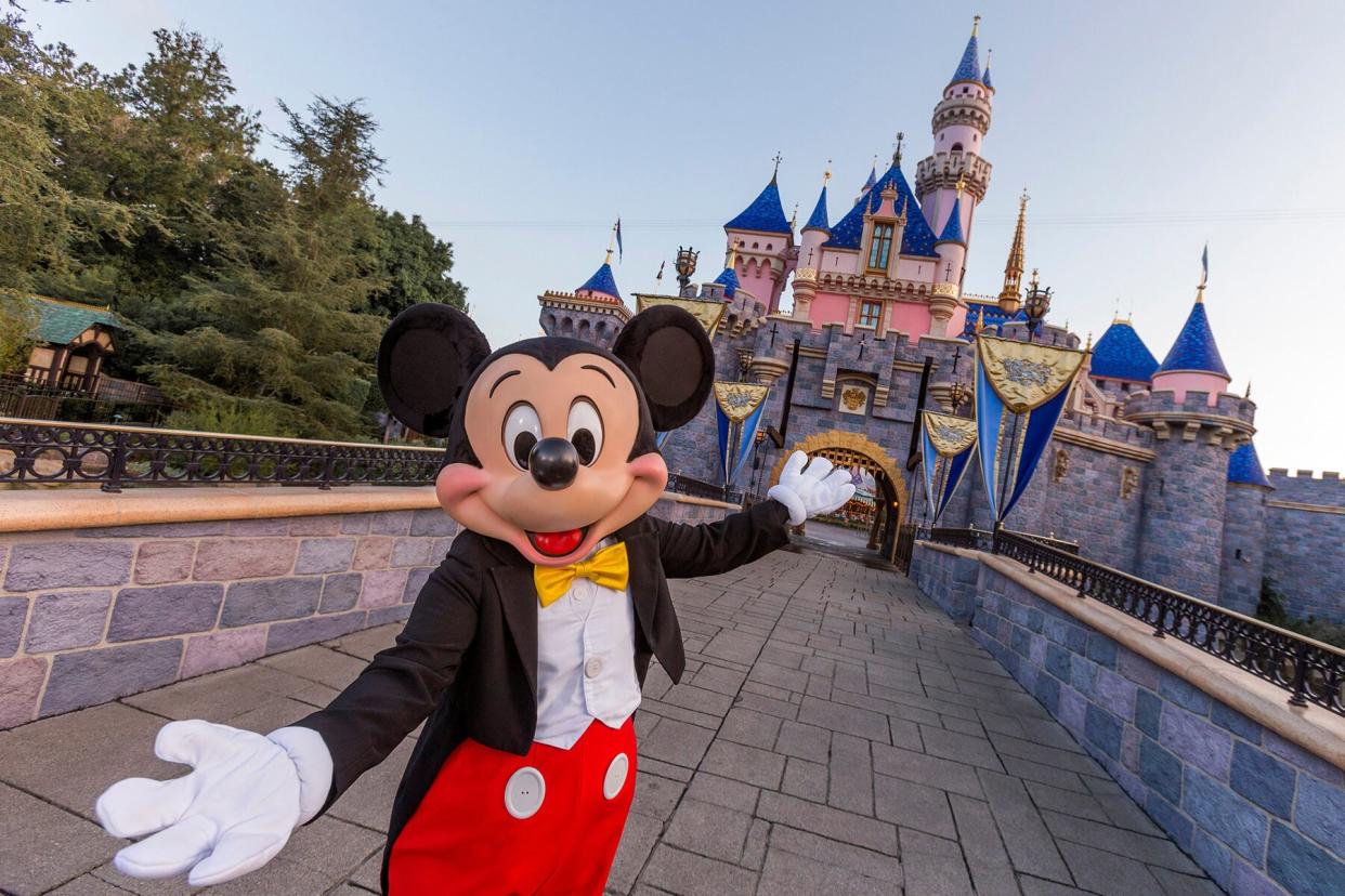 Mickey Mouse poses in front of Sleeping Beauty Castle at Disneyland Park in Anaheim, California