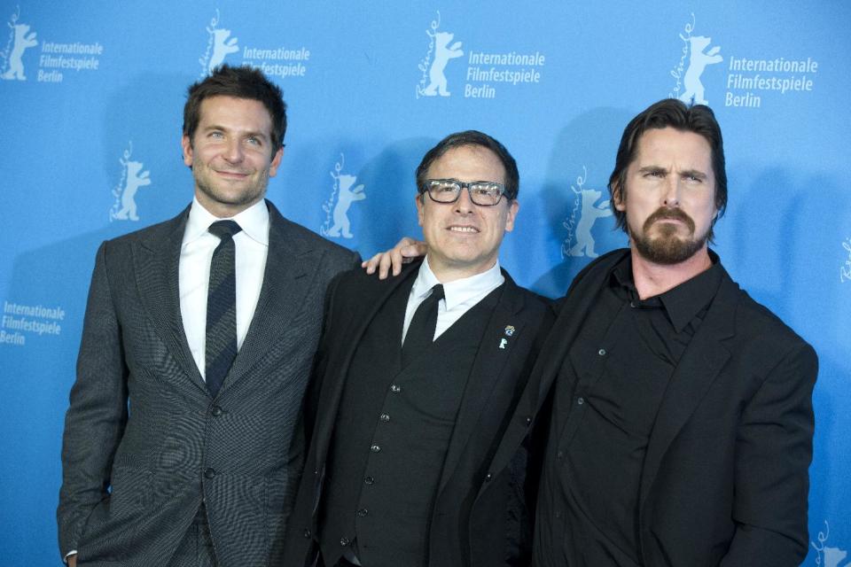 From left, actor Bradley Cooper, director David O. Russell and actor Christian Bale pose for photographers during the photo call for the film American Hustle during the International Film Festival Berlinale, in Berlin, Friday, Feb. 7, 2014. (AP Photo/Axel Schmidt)