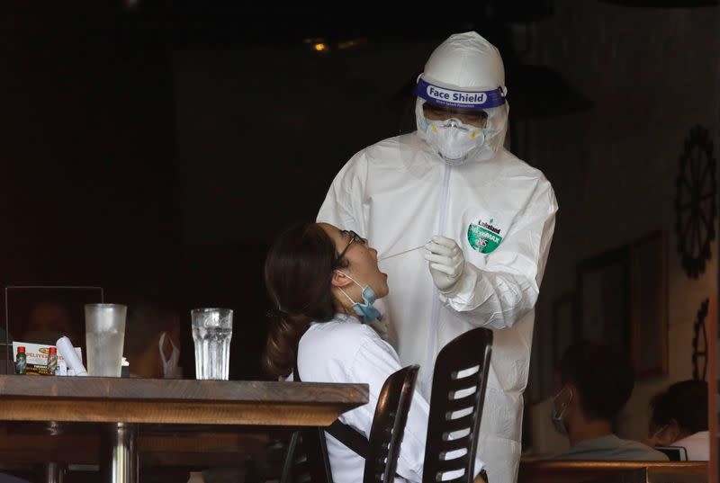 A health worker of Hanoi CDC gets testing sample of an employee of a pizza restaurant in Hanoi