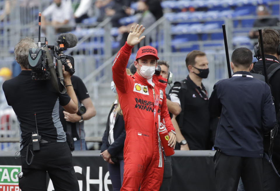 Ferrari driver Charles Leclerc of Monaco, center, waves after the qualifying session at the Monaco racetrack, in Monaco, Saturday, May 22, 2021. The Formula One race will take place on Sunday with Ferrari driver Charles Leclerc of Monaco in pole position. (AP Photo/Luca Bruno)
