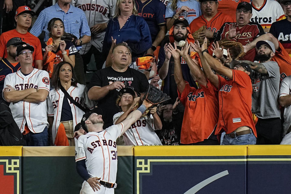 Houston Astros right fielder Kyle Tucker can't get a glove on a home run by Philadelphia Phillies' J.T. Realmuto during the 10th inning in Game 1 of baseball's World Series between the Houston Astros and the Philadelphia Phillies on Friday, Oct. 28, 2022, in Houston. (AP Photo/Eric Gay)