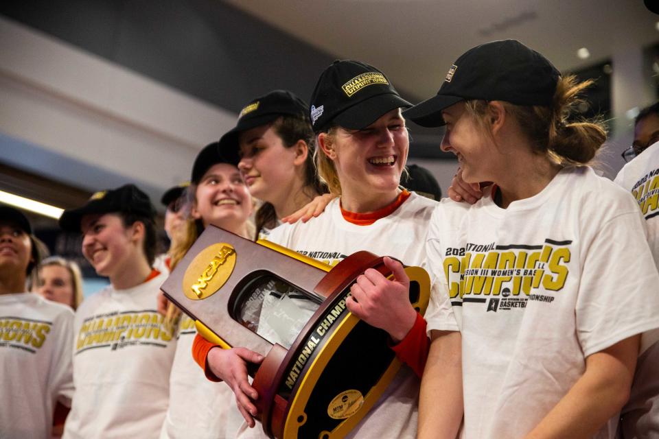 Hope's Sydney Muller smiles as she holds the DIII national championship trophy Saturday, March 19, 2022, at UPMC Cooper Fieldhouse in Pittsburgh. 