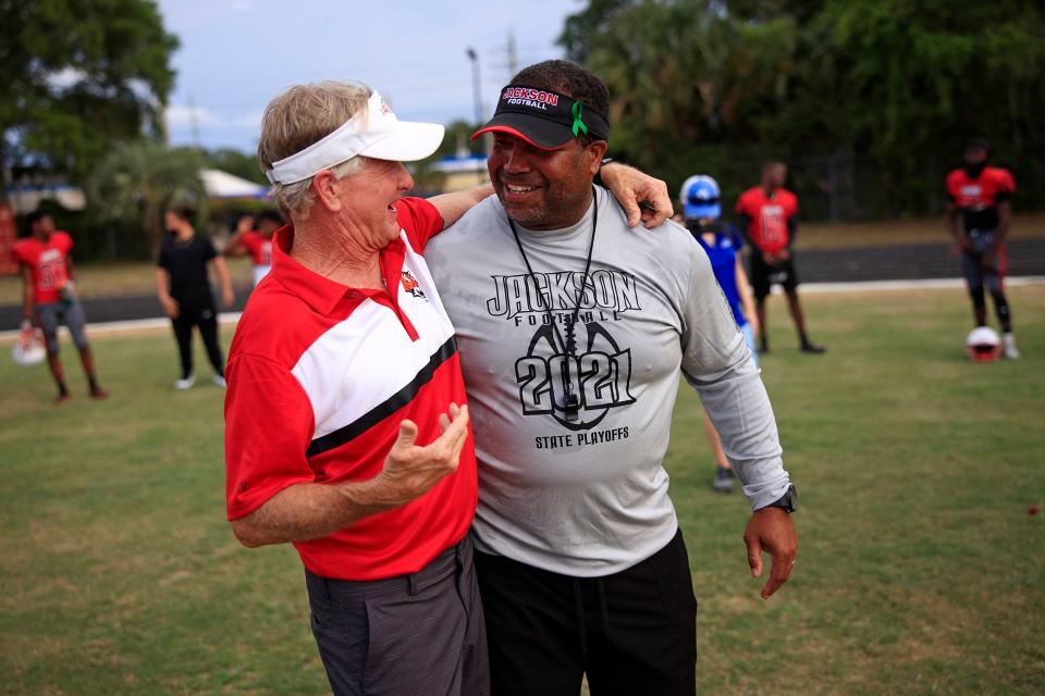 Former head coach and athletic director Kevin Sullivan, left, smiles as he talks with Andrew Jackson High School head football coach Christopher Foy before a scrimmage game Friday.