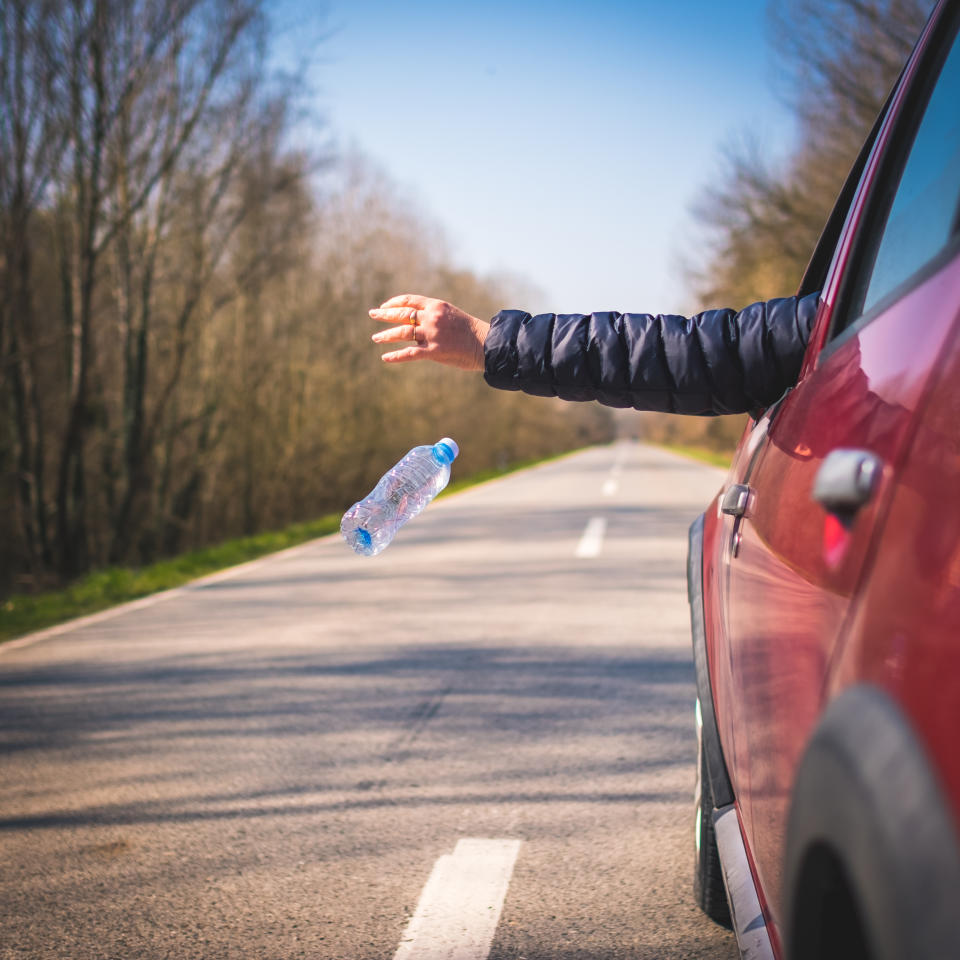 Driver of car throwing bottle out of window. Source: Getty Images