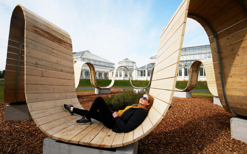 <p>Visitor programme manager Kate Solecki rests on a portion of the Paul Cocksedge 2019 London Design Festival piece 'Please Be Seated' at the new visitor attraction Secret World of Plants at Kew Gardens, London, which runs from May 1st to September 19th, 2021. Picture date: Thursday May 6, 2021.</p>
