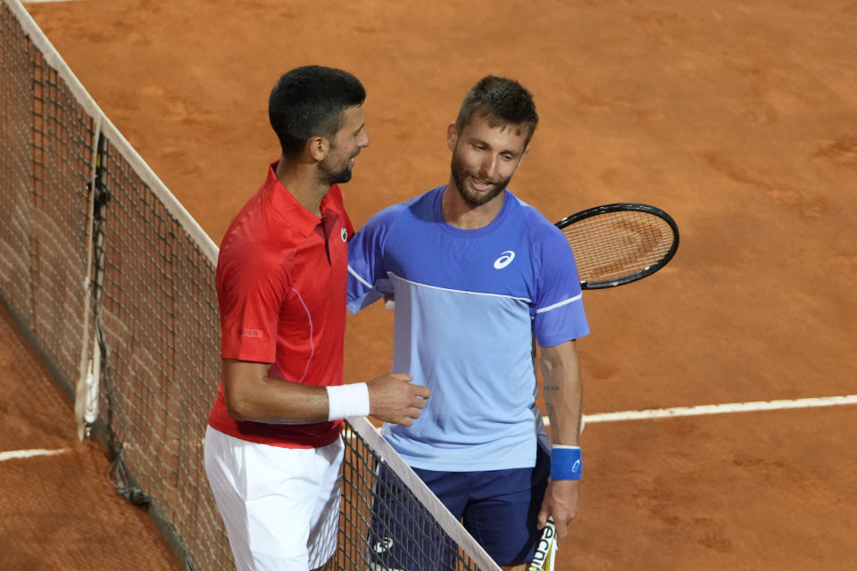 Serbia's Novak Djokovic, left, talks with France's Corentin Moutet at the end of their match at the Italian Open tennis tournament in Rome, Friday, May 10, 2024. Djokovic won. (AP Photo/Alessandra Tarantino)