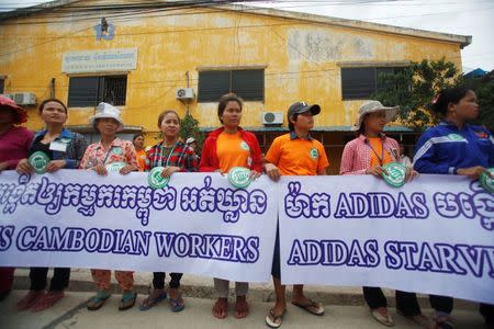 Garment workers hold banners during a protest calling for higher wages in Phnom Penh September 17, 2014. REUTERS/Samrang Pring