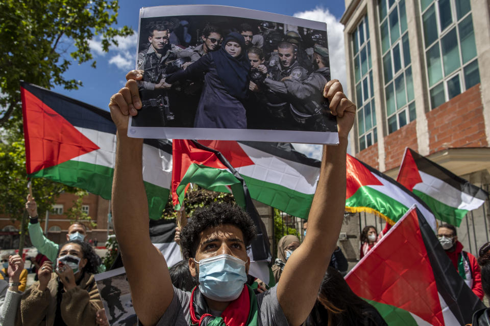 Protesters shout slogans and wave Palestinian flags in support of Palestinians during the latest round of violence, outside the Israeli embassy in Madrid, Spain, Tuesday, May 11, 2021. (AP Photo/Manu Fernandez)