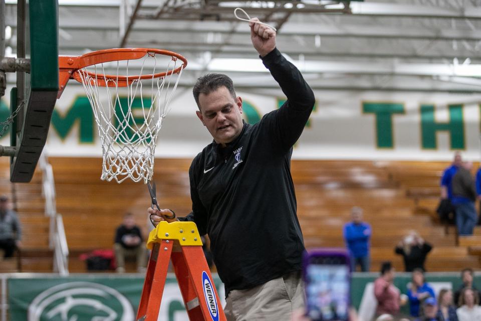 Marian’s Robb Berger cuts a piece of the net after the Culver Academy-Marian high school 3A boys regional basketball game on Saturday, March 12, 2022, at Washington High School in South Bend, Indiana.