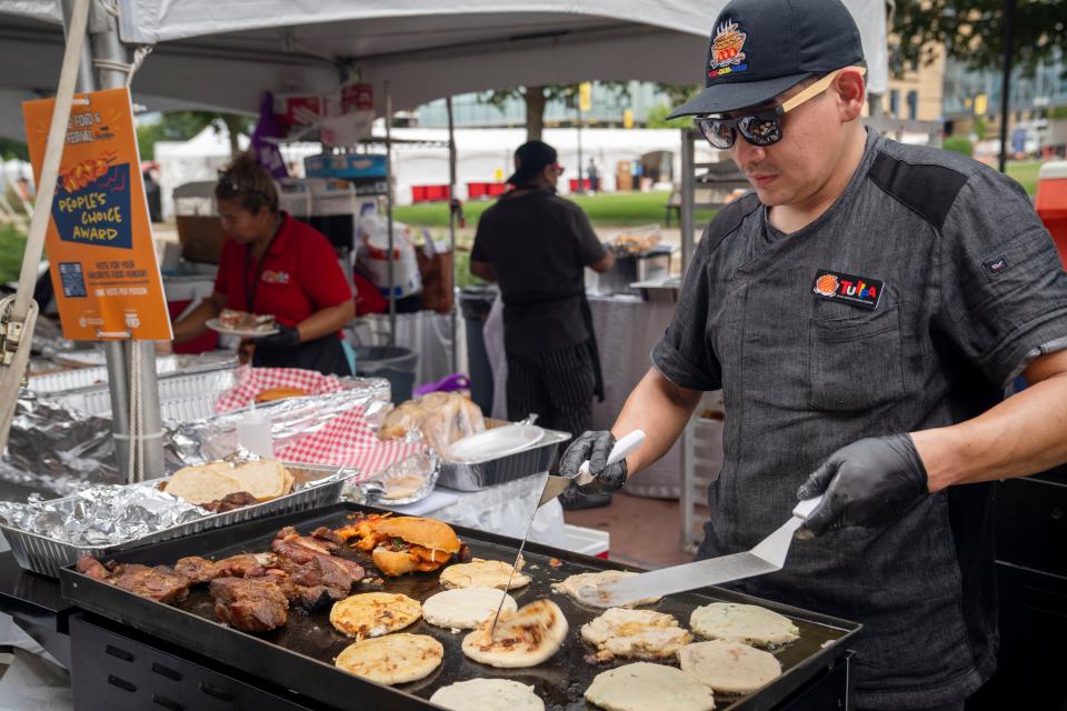 Luis Carion prepares pupusas at the booth for Tullpa, a Peruvian restaurant, during the World Food and Music Festival in Des Moines' Western Gateway Park on Aug. 25.