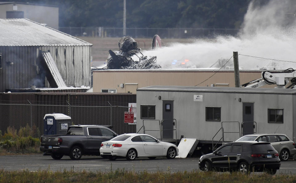 A fire-and-rescue operation is underway where World War II-era bomber plane crashed at Bradley International Airport in Windsor Locks, Conn., Wednesday, Oct. 2, 2019. A fire with black smoke rose from near the airport as emergency crews responded. The airport said in a message on Twitter that it has closed. (AP Photo/Jessica Hill)