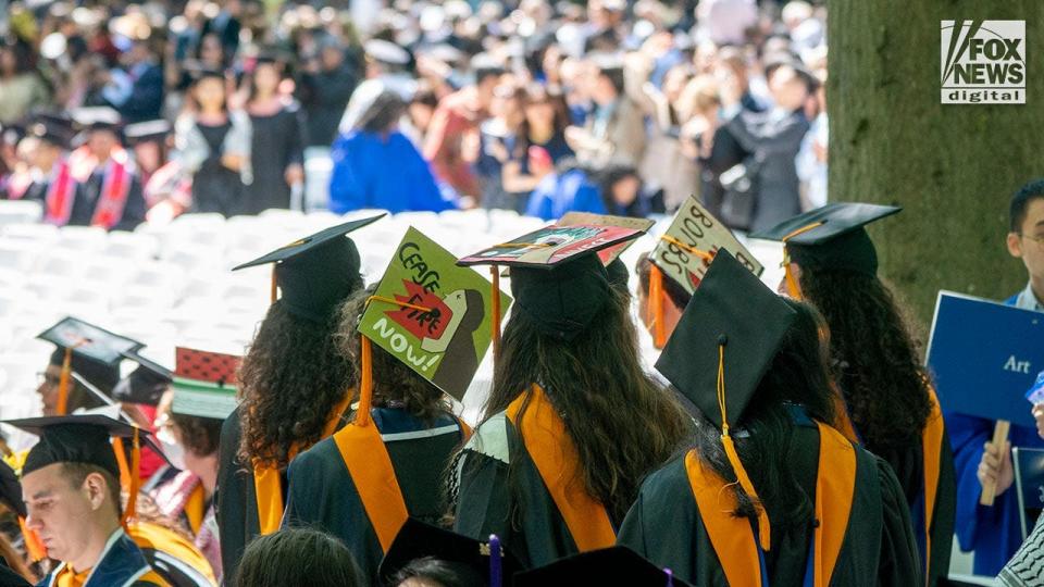 Yale graduates protest the Hamas-Israel war with signs painted on their caps