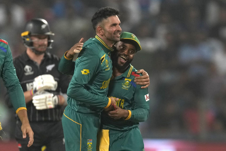 South Africa's Keshav Maharaj, left, celebrates the wicket of New Zealand's Jimmy Neesham with South Africa's captain Temba Bavuma during the ICC Men's Cricket World Cup match between New Zealand and South Africa in Pune, India, Wednesday, Nov.1, 2023. (AP Photo/Manish Swarup)