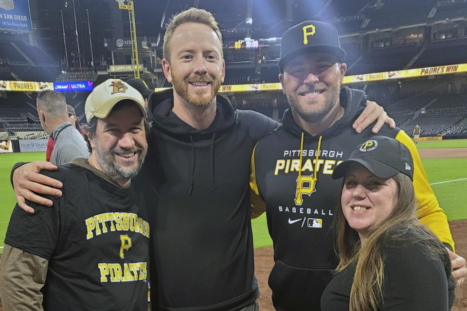 In this photo provided by Lora Greco, Matt, left, and Lora Greco, right, pose with San Diego Padres' Steve Wilson, second from left, and Pittsburgh Pirates' David Bednar at Petco Park in 2022. Lora and Matt Greco hosted players in Lake Elsinore — a Class A affiliate for the San Diego Padres — for three seasons from 2017-19. Their tenants included future big-league pitchers Joey Lucchesi and David Bednar. Host family programs were suspended during the coronavirus pandemic over health concerns. Now, they may never return. (Photo courtesy Lora Greco via AP)