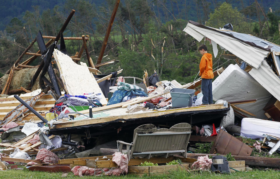 FILE - Caleb Pander, 10, stands on a wall of a home destroyed by high winds in the Camp Creek Community on April 28, 2011, in Greeneville, Tenn. Meteorologists are warning of a series of severe storms that could rip across America’s Midwest and South over the next couple of weeks. One weather expert said the current persistent pattern of storm ingredients is consistent with the April 2011 tornado onslaught, one of the largest, deadliest and most destructive tornado outbreaks in American history. (AP Photo/Wade Payne, File)