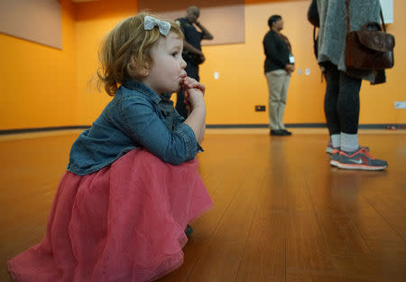 A girl takes a candy break as her mother listens to Stacey Abrams, Democratic gubernatorial candidate for Georgia, in Riverdale, Georgia, October 27, 2018 ahead of the midterm elections. REUTERS/Lawrence Bryant