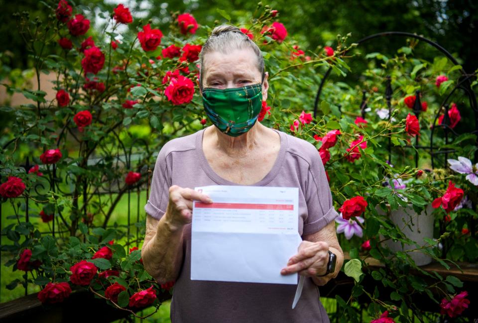 Linda Gurley holds a bill from IU Health Hospital Bloomington in her yard on Thursday, May 27, 2022.