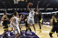 Northwestern center Ryan Young (15) grabs a rebound during the first half of the team's NCAA college basketball game against Iowa on Tuesday, Jan. 14, 2020, in Evanston, Ill. (AP Photo/David Banks)