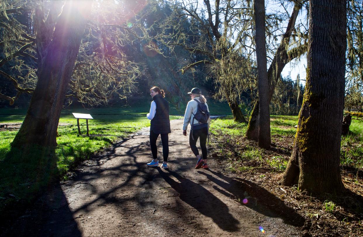 Kallan Link, left, and Chantel Anderson enjoy a walk in the sun at Mount Pisgah Arboretum on Friday, the first day the park was open to the public after being closed by ice storm damage in January.