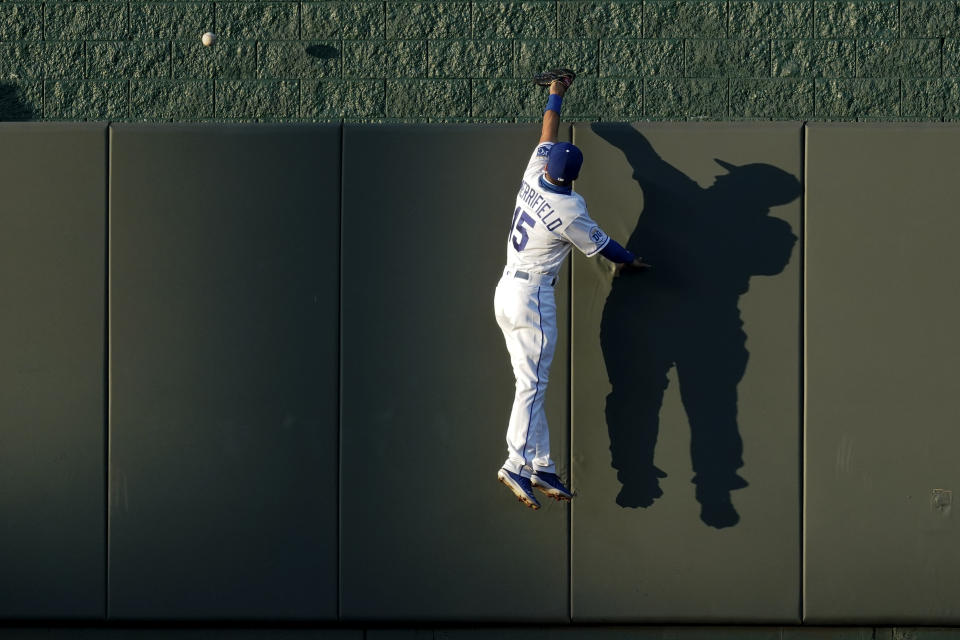 Kansas City Royals center fielder Whit Merrifield can't catch a solo home run ball hit by Cincinnati Reds' Eugenio Suarez during the third inning of game two of a baseball doubleheader Wednesday, Aug. 19, 2020, in Kansas City, Mo. (AP Photo/Charlie Riedel)