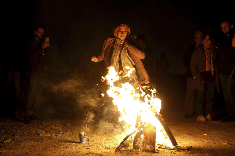 An Iranian woman jumps over a bonfire during a celebration, known as "Chaharshanbe Souri," or Wednesday Feast, marking the eve of the last Wednesday of the solar Persian year, in Tehran, Iran, Tuesday, March 19, 2019. Iran's many woes briefly went up in smoke on Tuesday as Iranians observed a nearly 4,000-year-old Persian tradition known as the Festival of Fire. (AP Photo/Ebrahim Noroozi)