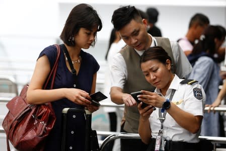 Security check people's boarding pass and travel documents at an entrance to Terminal 1 of Hong Kong Airport