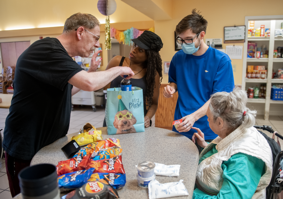 Direct support professionals Jameca England and Corey Austin, (center lr) work with residents Doug Damron and Brenda Lanhan in the kitchen of the Independence of Portage County group home.